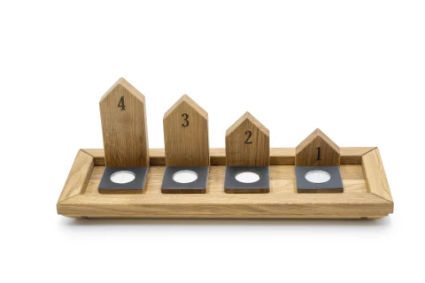 Vier h&ouml;lzerne Teelichthalter in Hausform auf einem rechteckigen Holztablett. Die Teelichthalter sind von links nach rechts ansteigend nummeriert von 4 bis 1 und haben schwarze B&ouml;den mit kreisf&ouml;rmigen Aussparungen f&uuml;r Teelichter.